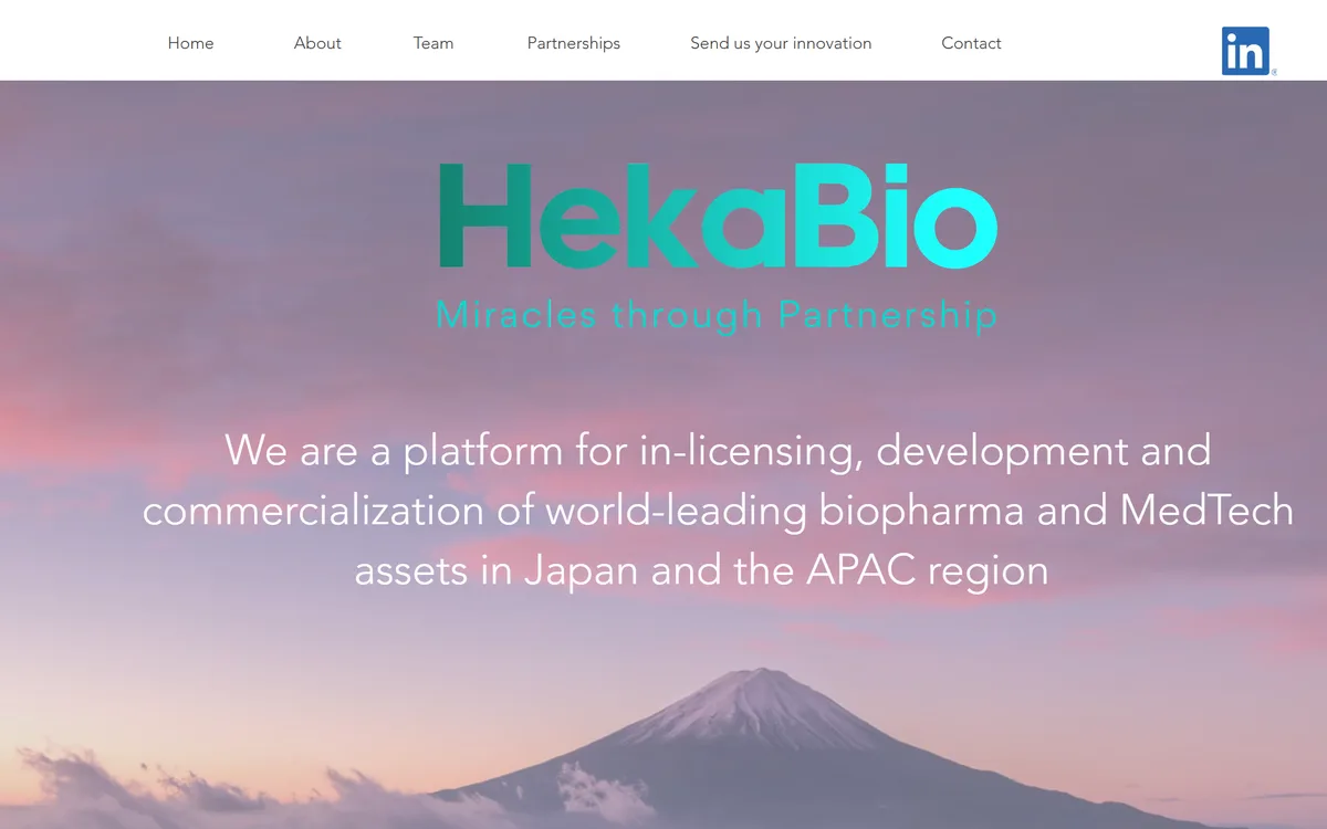HekaBio homepage — the HekaBio wordmark and “Miracles through Partnership” tagline over a Mount Fuji sunset, above a line describing the company as a biopharma and MedTech in-licensing platform for Japan and APAC